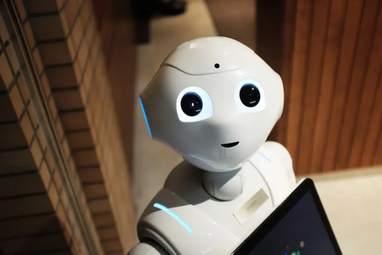 Close-up of a humanoid robot with expressive eyes and a touchscreen, symbolizing friendly and collaborative artificial intelligence.