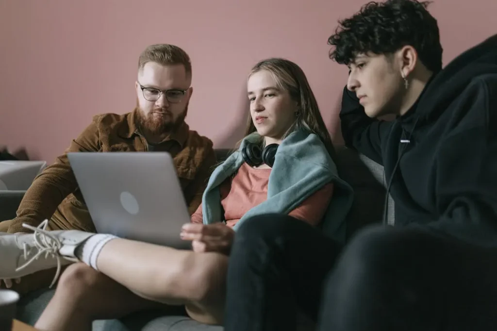 oung adults researching the best investment accounts for young adults together on a laptop.