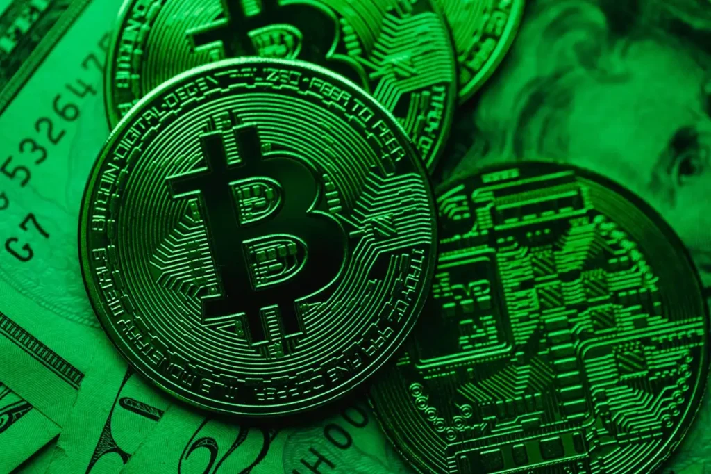 Close-up of Bitcoin cryptocurrency coins overlaid on U.S. dollar bills with green lighting, symbolizing cryptocurrency investing.