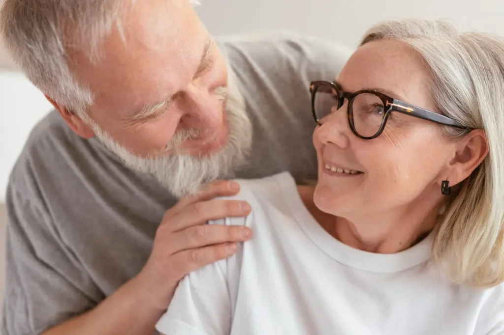 Smiling senior couple sharing a warm moment, symbolizing the rewards of knowing how much to save for retirement and achieving financial freedom.
