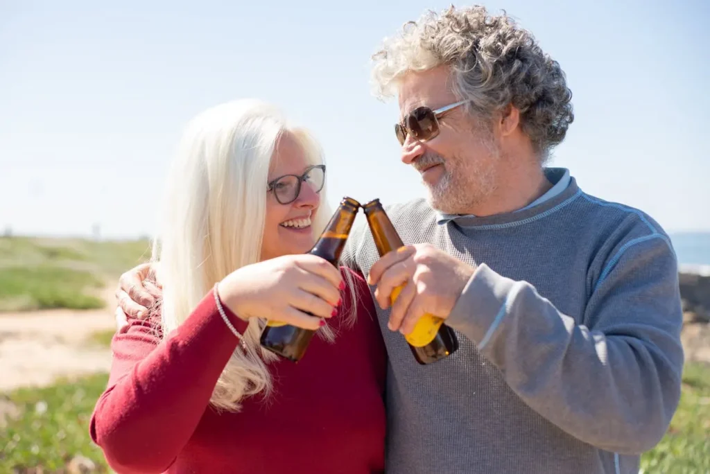 Smiling retired couple enjoying a drink outdoors on a sunny day, symbolizing a carefree lifestyle abroad made possible by retirement visas for U.S. citizens.