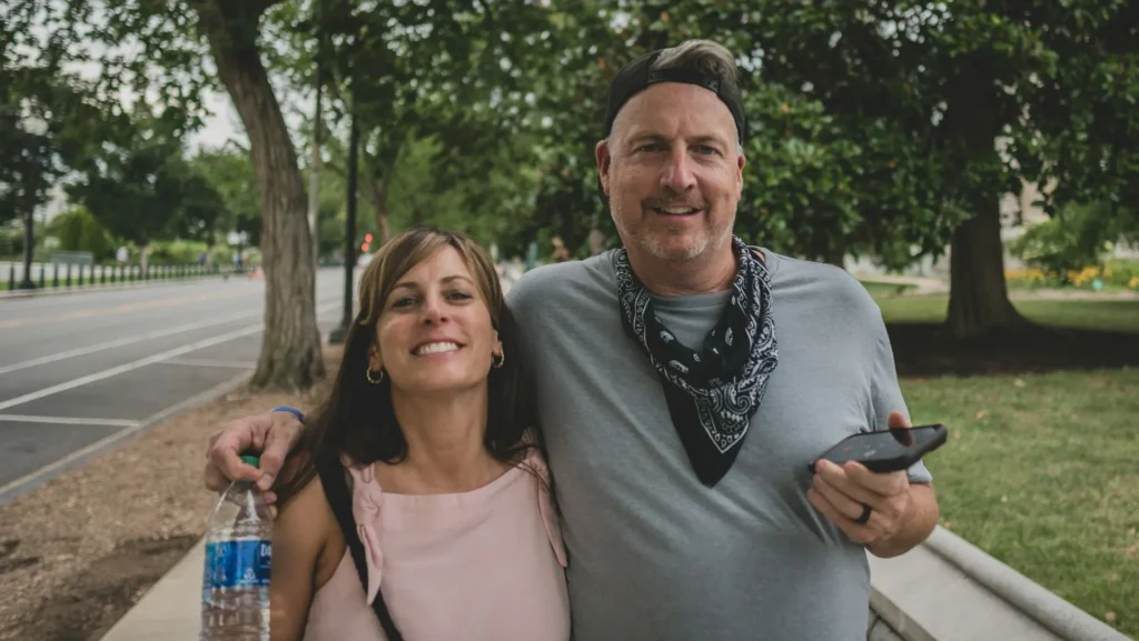 Smiling middle-aged couple exploring a neighborhood together, thinking about future retirement plans and researching the best places to retire in the U.S.