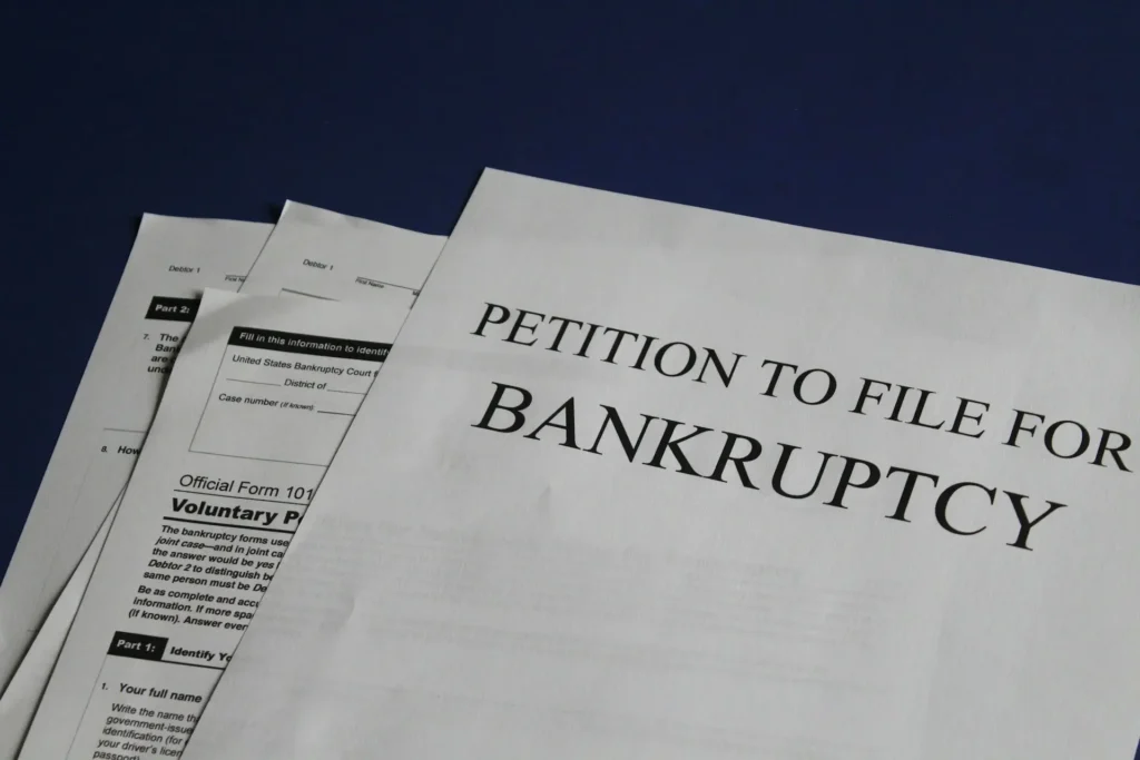 Bankruptcy petition forms on a desk, highlighting the process of filing for debt relief in the U.S., including the treatment of personal loans in bankruptcy.