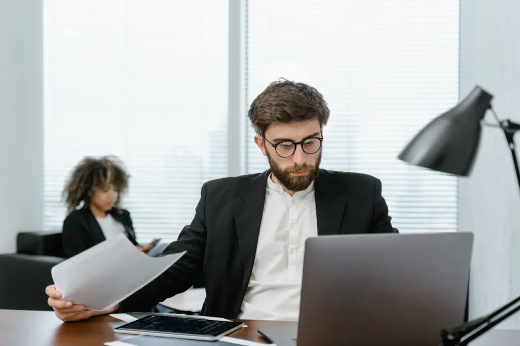 Professional analyst reviewing offshore investing for Americans documents on a laptop in a modern office setting.