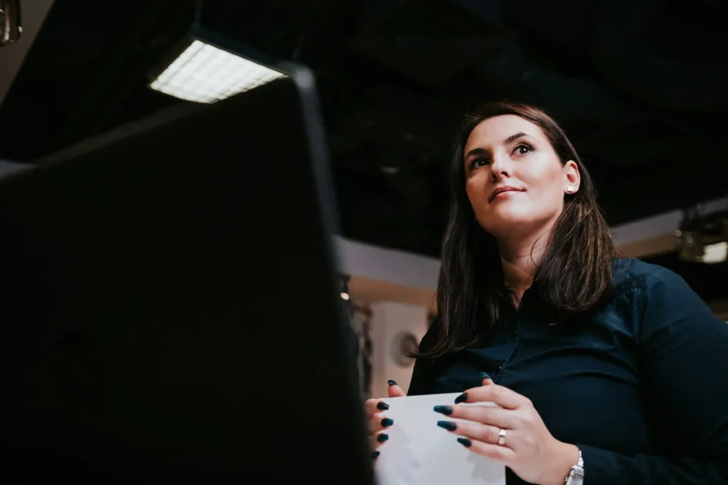 Confident woman in her 40s holding a document and reflecting on how much to save for retirement by age 40.