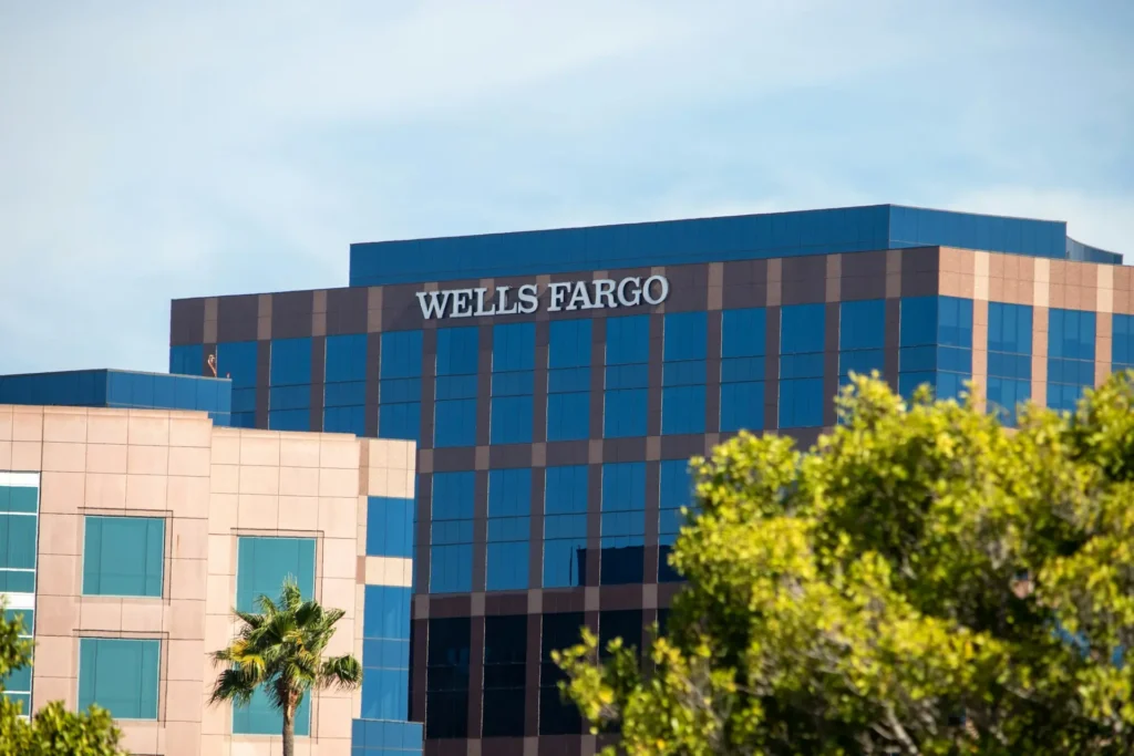 Wells Fargo office building with reflective glass windows on a clear sunny day in the U.S., representing the credit union vs. bank choice for personal loans.