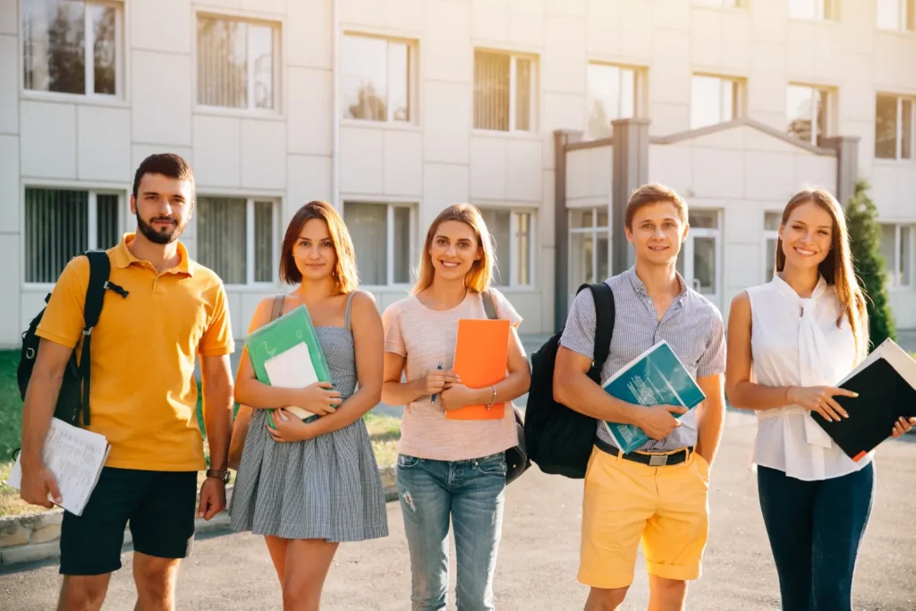 Smiling students on campus preparing for college life, highlighting how to apply for student loans successfully.