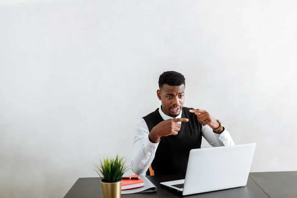 Young professional American man looking concerned while checking IRS stimulus checks rumor on a laptop at his desk.
