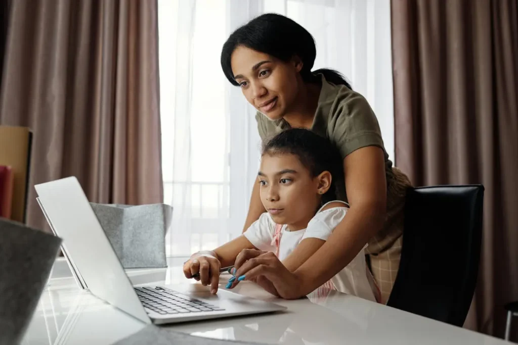 Student attending a live lesson on an online tutoring platform, like Cambly, with parental support at home.