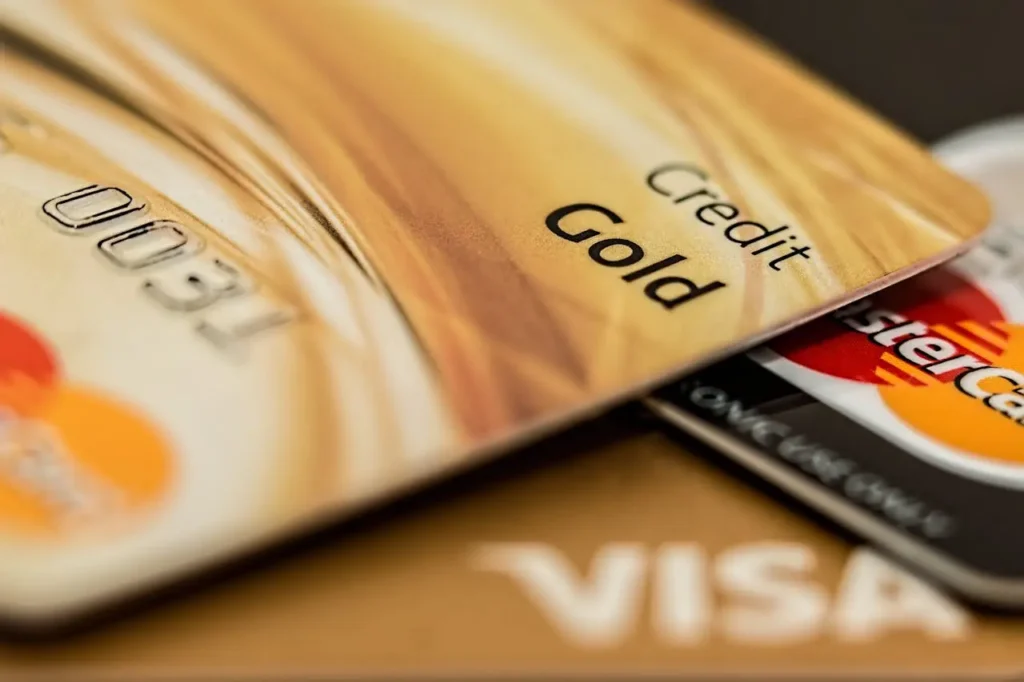 Close-up of gold and black credit cards including Mastercard and Visa logos, representing premium credit cards.